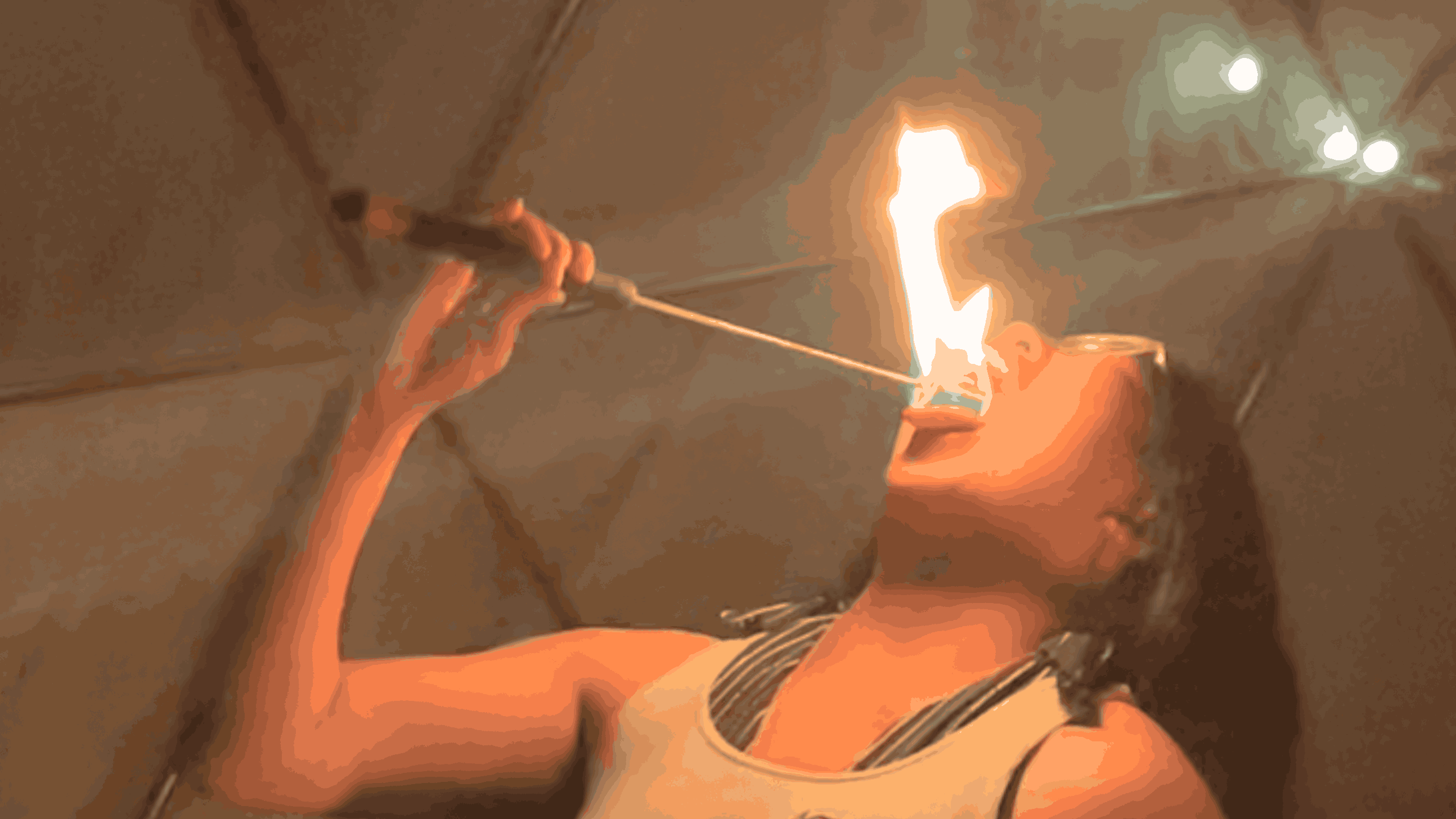 A person performs a fire-eating act, tilting their head back with their mouth open as…